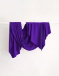 Le Murmure purple scarf, soft and feminine, drapes lightly around the neck or shoulders